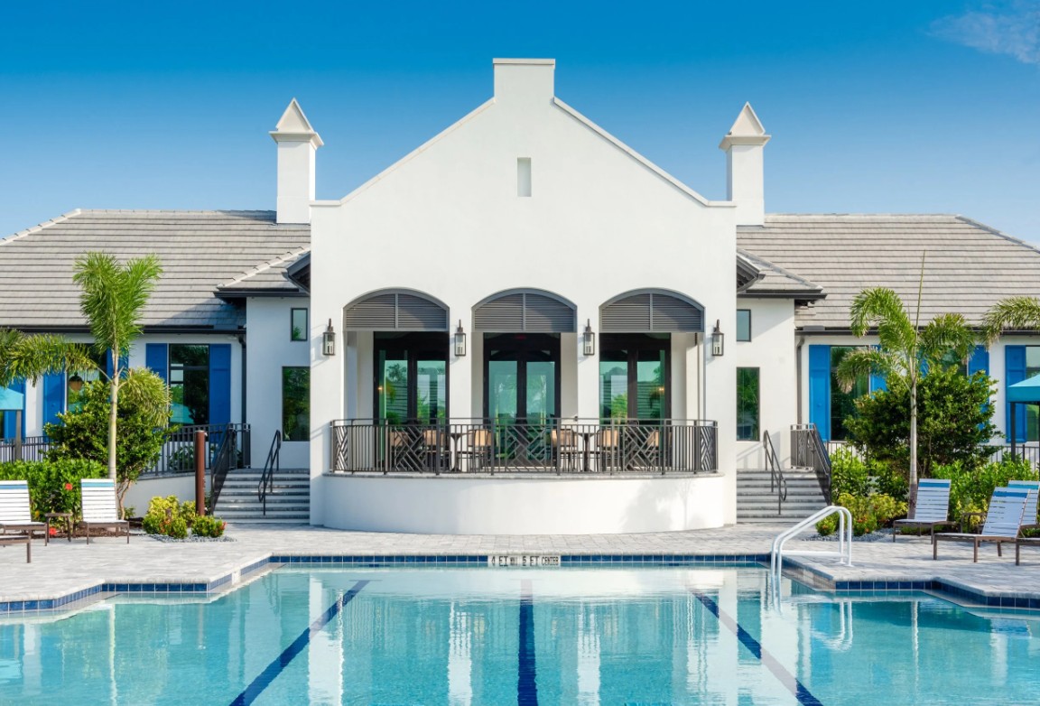 Resort-style amenity center with pool and tropical landscape at Windward Lakewood Ranch