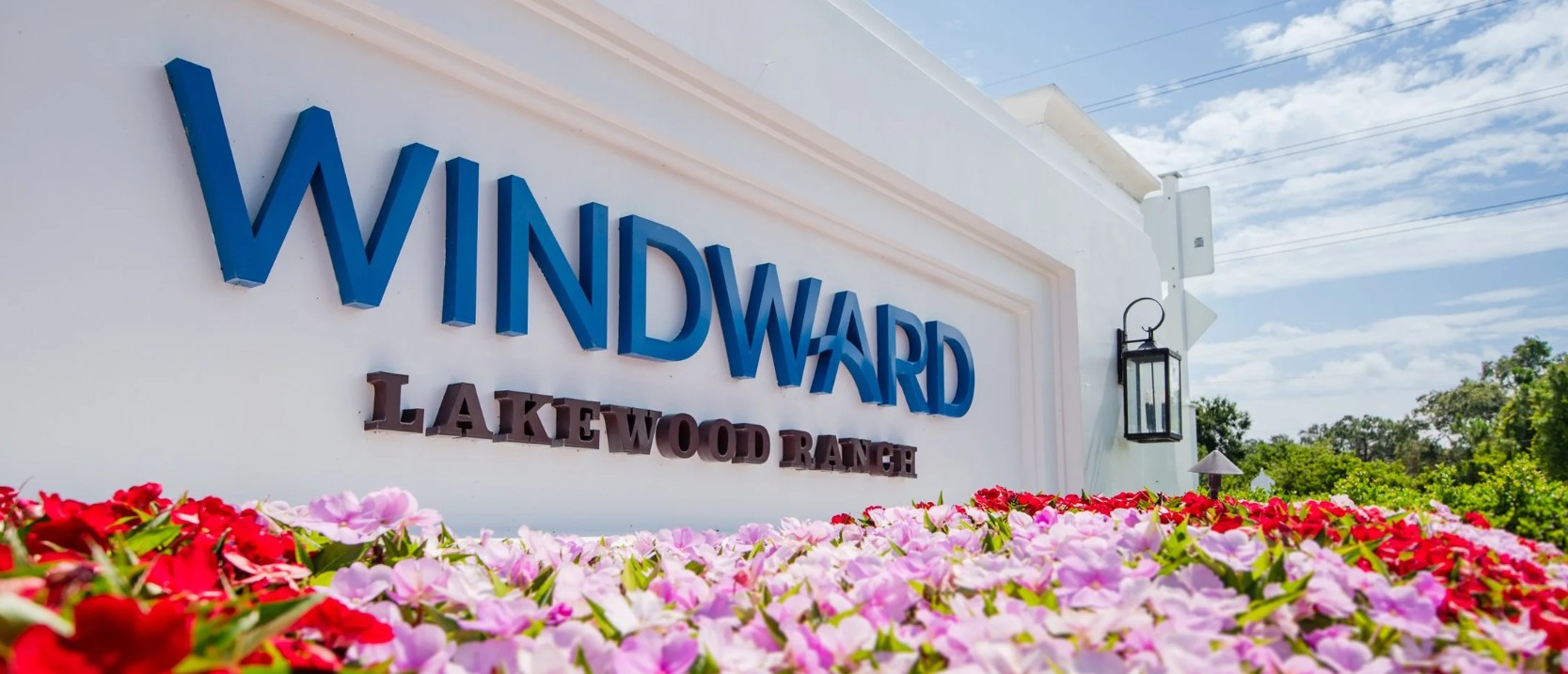 Windward Lakewood Ranch — community entry monument with lush floral landscape