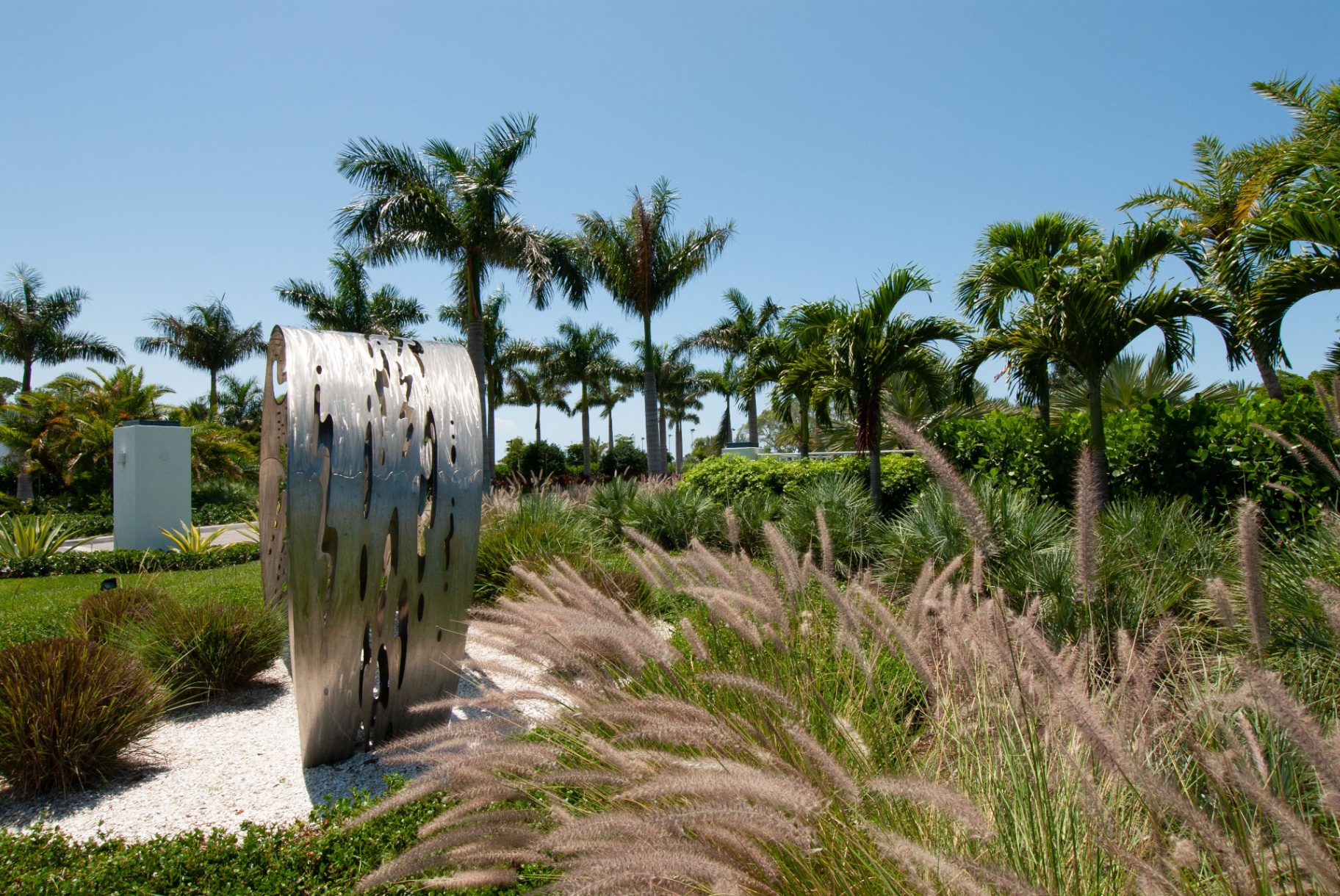Stainless steel sculpture set among ornamental grasses and palms at The Resort at Longboat Key Club