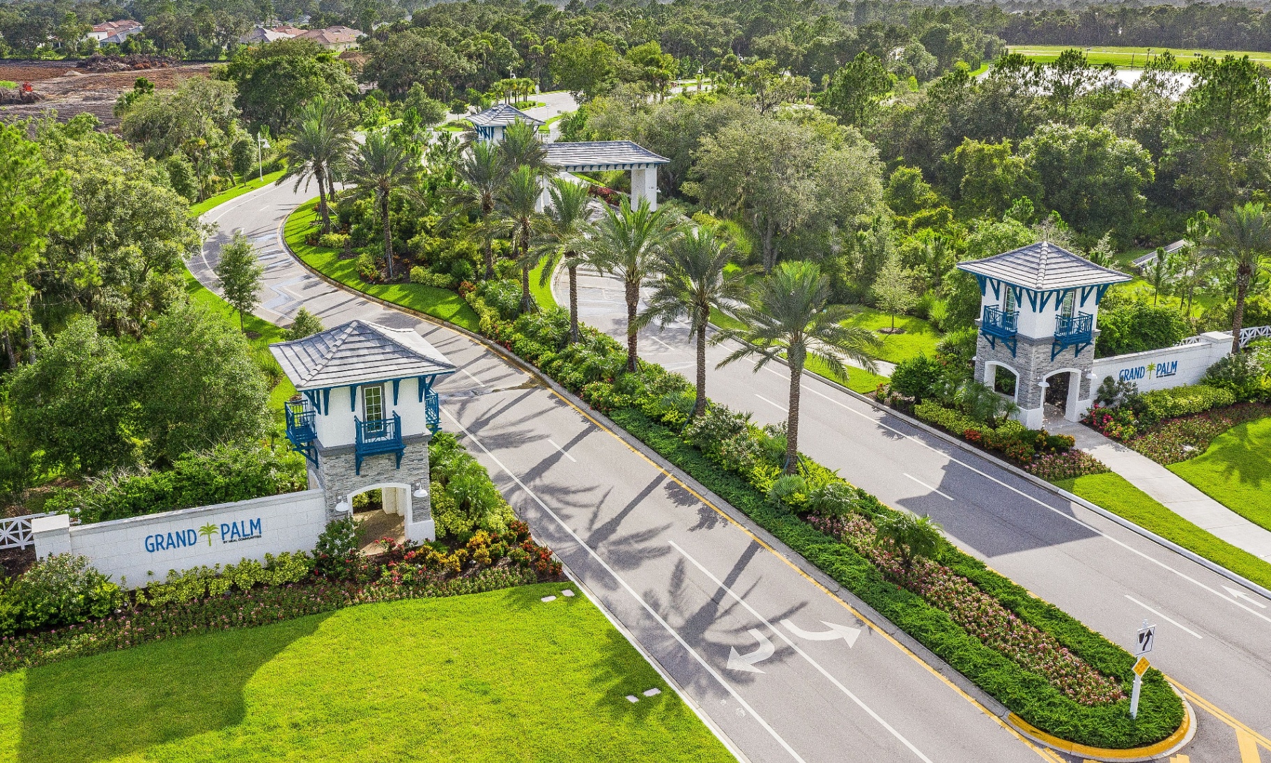Aerial view of the Grand Palm entrance gatehouse and palm-lined boulevard